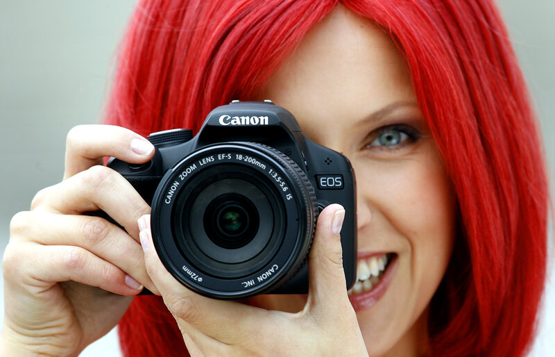 woman with red hair holding camera