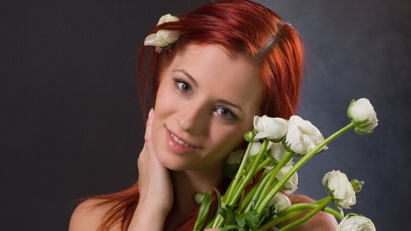 woman with red hair holding flowers