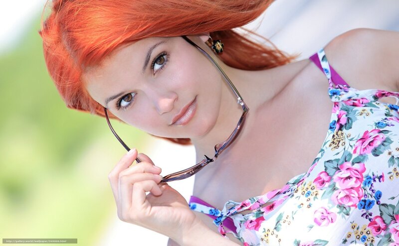 woman with red hair holding glasses