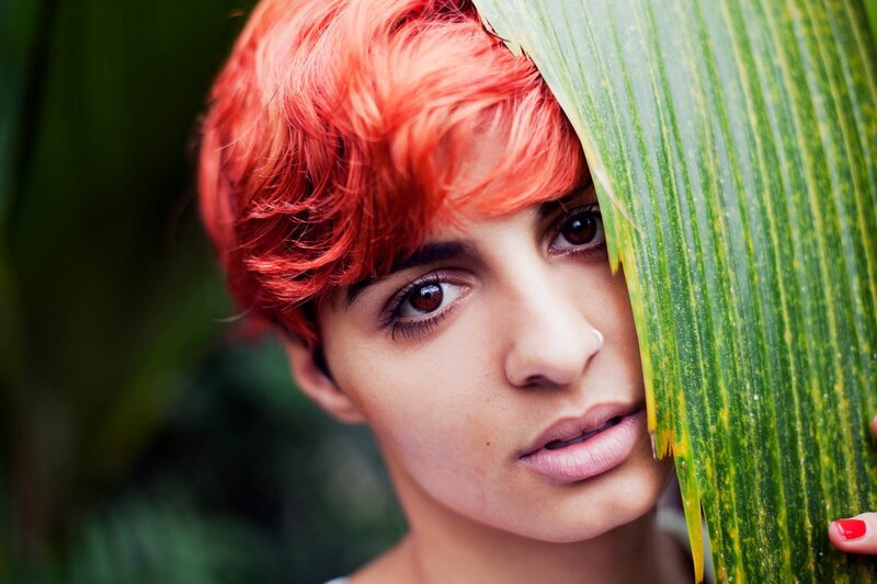 woman with red hair holding leaf