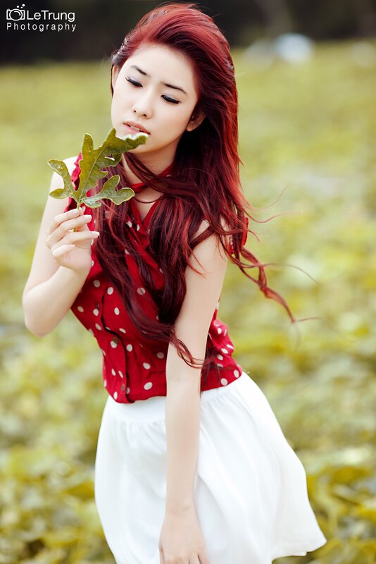 woman with red hair holding leaf