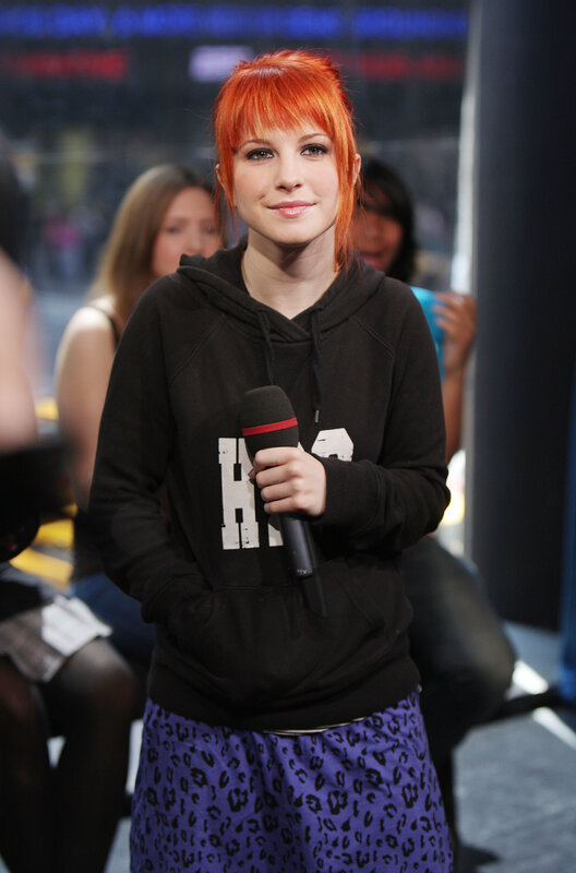 woman with red hair holding microphone
