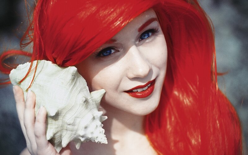 woman with red hair holding shell