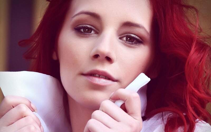 woman with red hair holding tissue