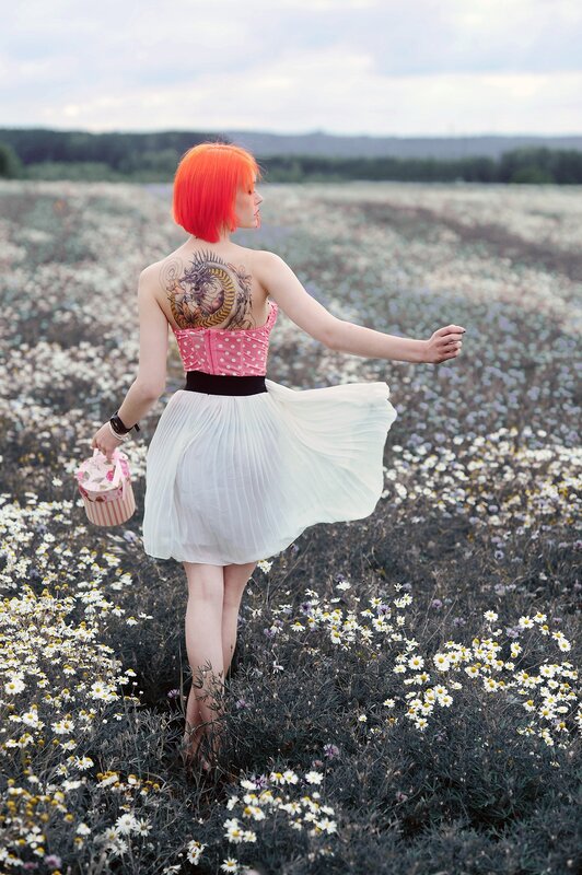 Woman with red hair in a flower field