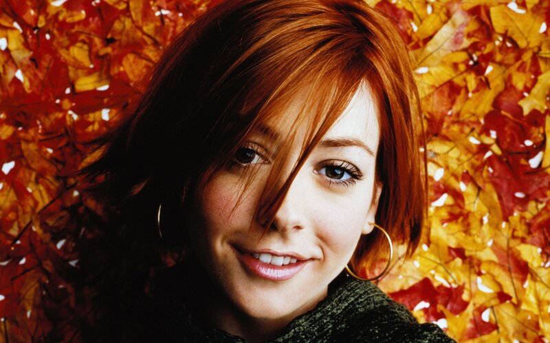 woman with red hair in autumn leaves