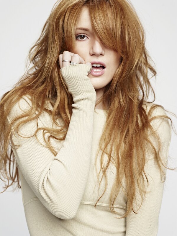 woman with red hair in beige sweater