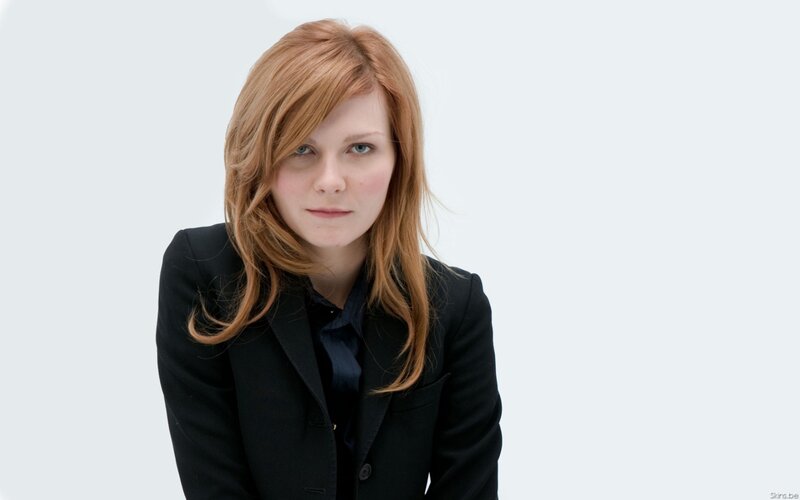 woman with red hair in black blazer