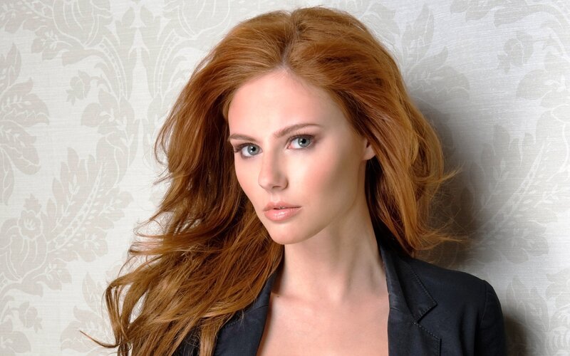 woman with red hair in black blazer