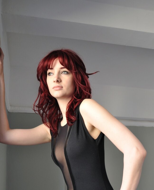 woman with red hair in black top