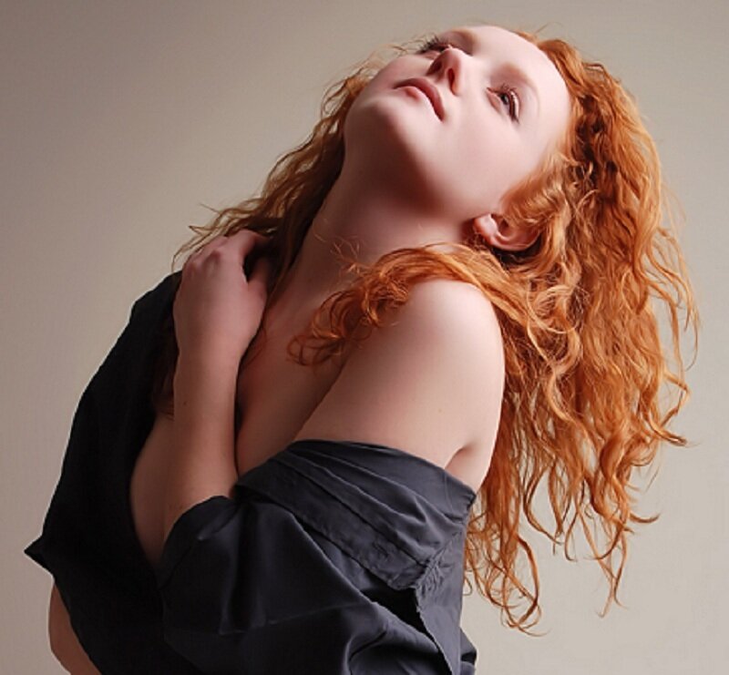 woman with red hair in black top