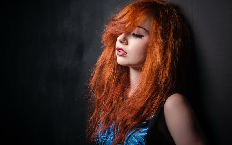 woman with red hair in dark room