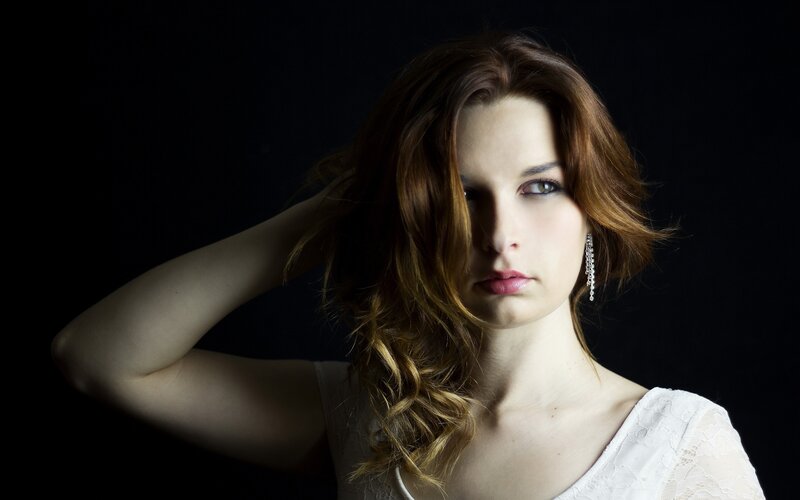 woman with red hair in dark studio