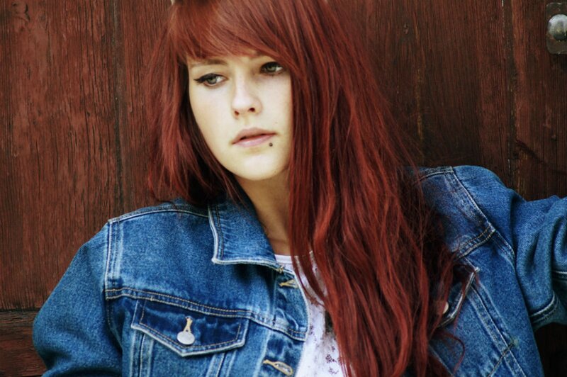 woman with red hair in denim jacket