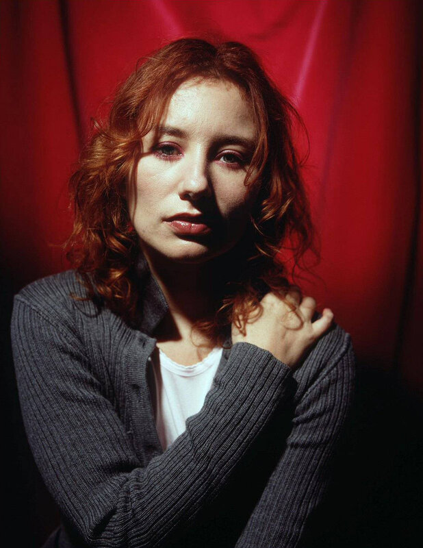 woman with red hair in front of curtain
