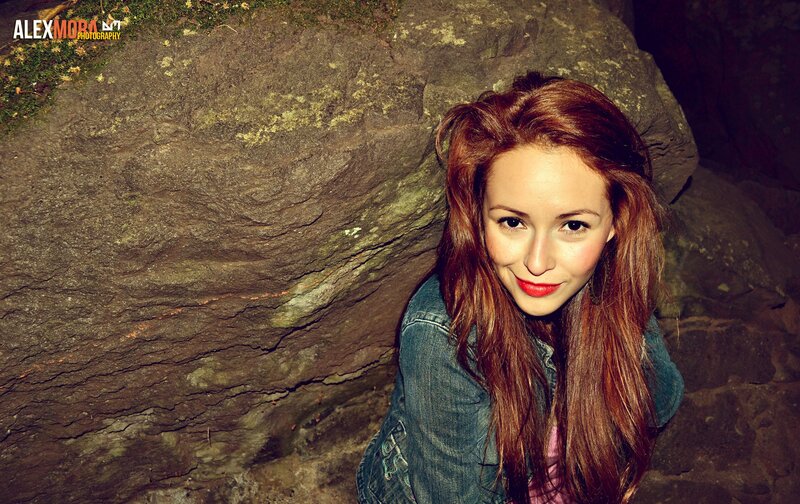 woman with red hair in front of rock