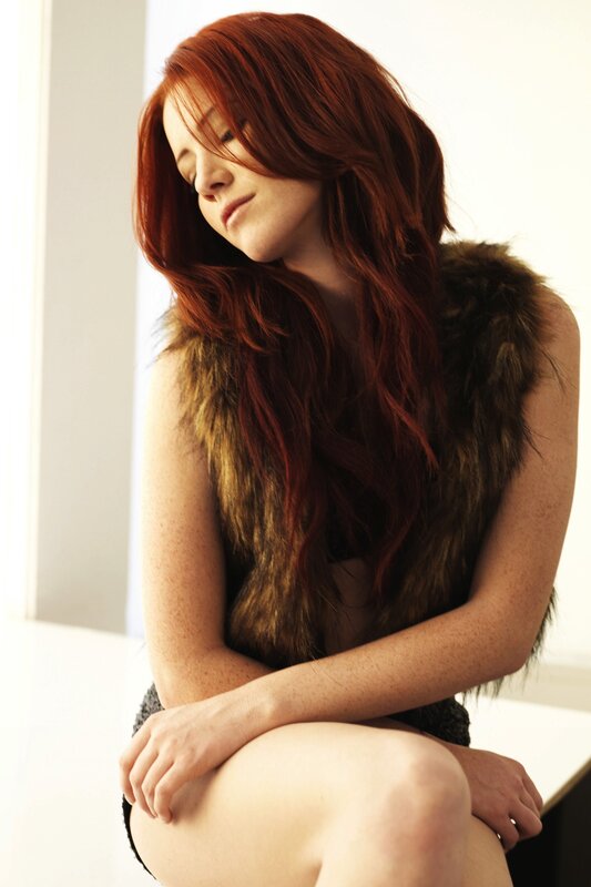 woman with red hair in fur vest
