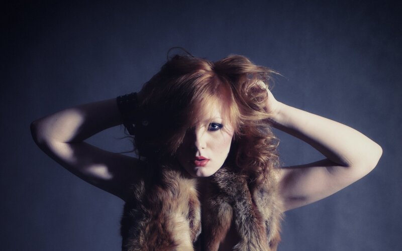 woman with red hair in fur vest