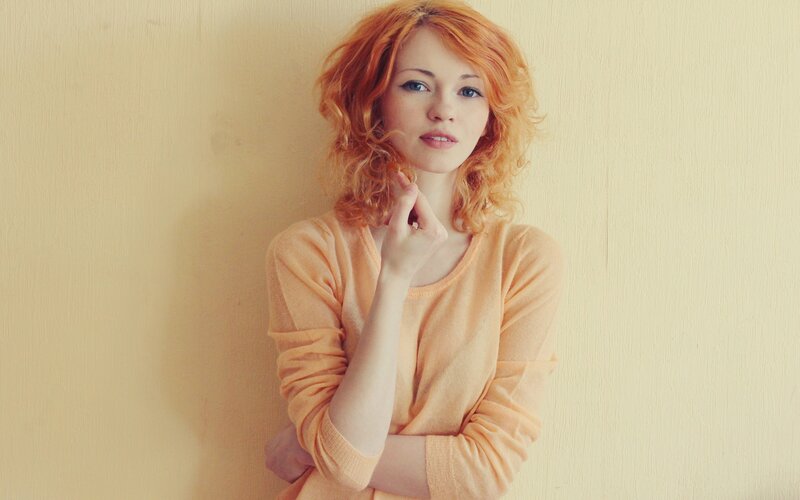 woman with red hair in orange sweater
