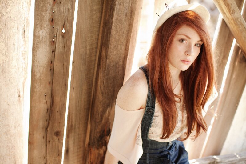 woman with red hair in overalls
