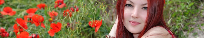 woman with red hair in poppy field