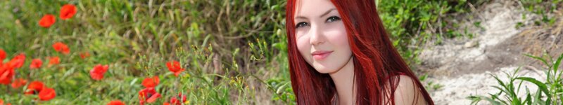 woman with red hair in poppy field