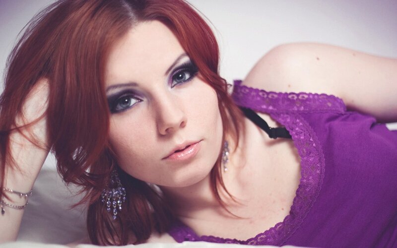woman with red hair in purple top