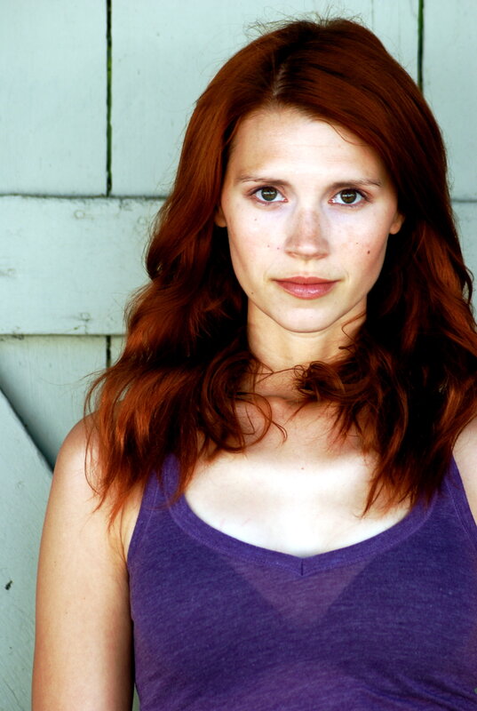 woman with red hair in purple top