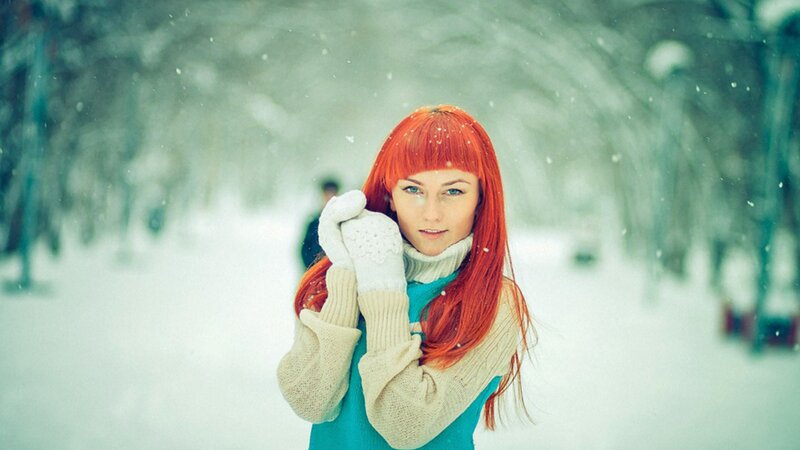Woman with red hair in snowy park