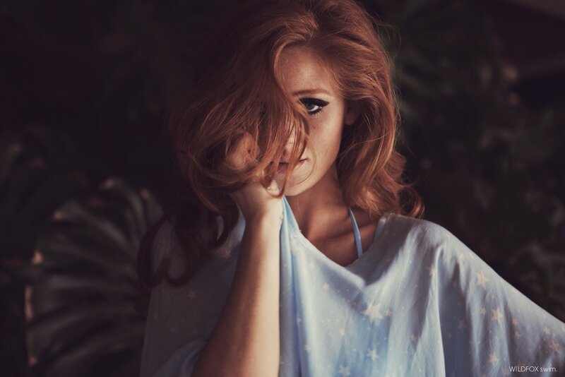 woman with red hair in star-patterned top
