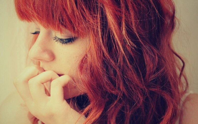 woman with red hair in thought