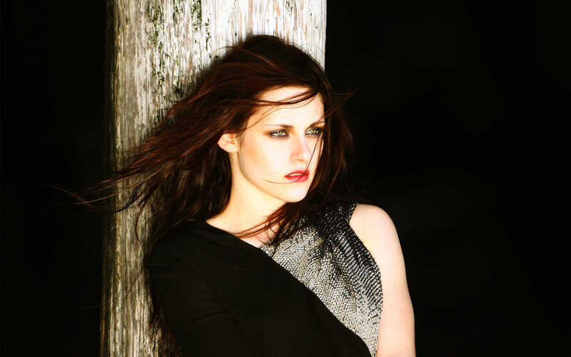 woman with red hair leaning on a post