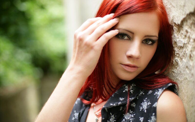 woman with red hair leaning on wall