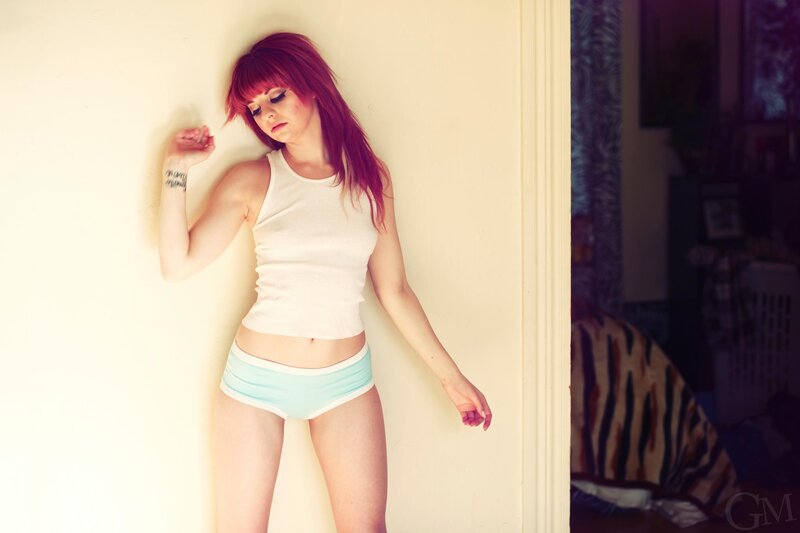 woman with red hair leaning on wall