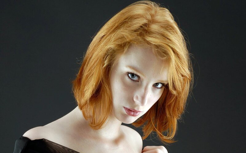 woman with red hair looking at camera