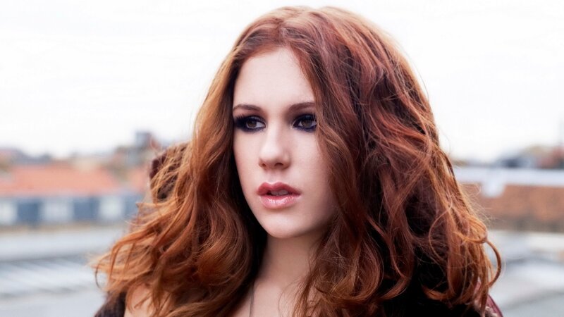 woman with red hair looking at camera