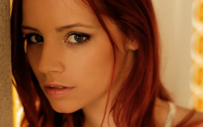 woman with red hair looking at camera