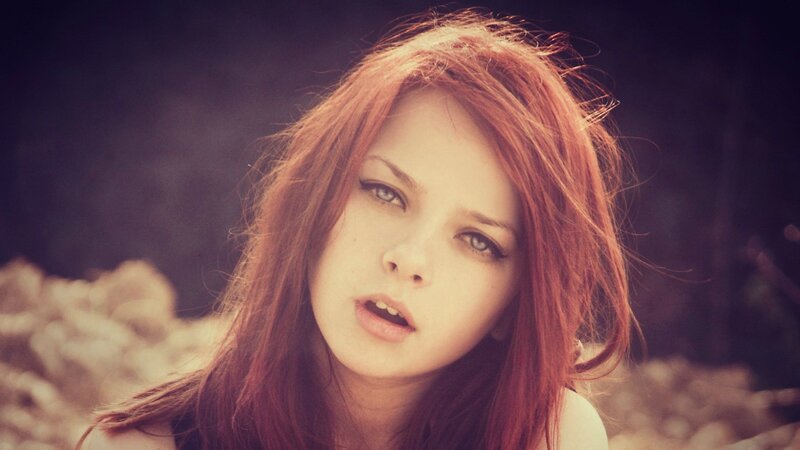 woman with red hair looking at camera