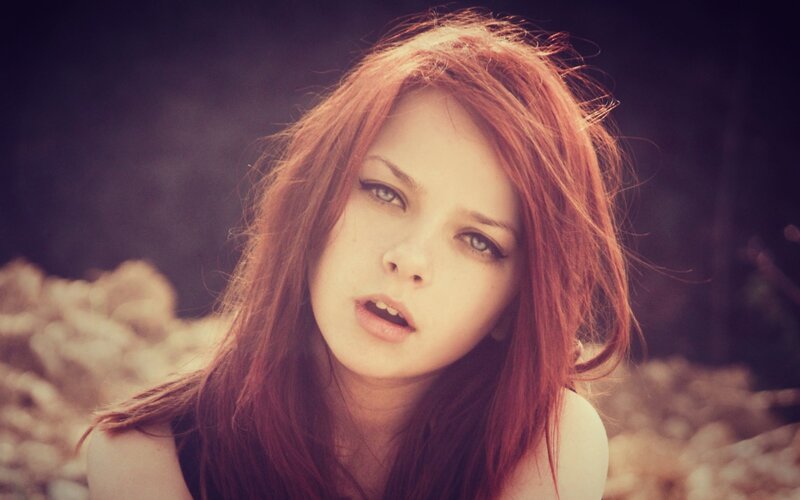 woman with red hair looking at camera