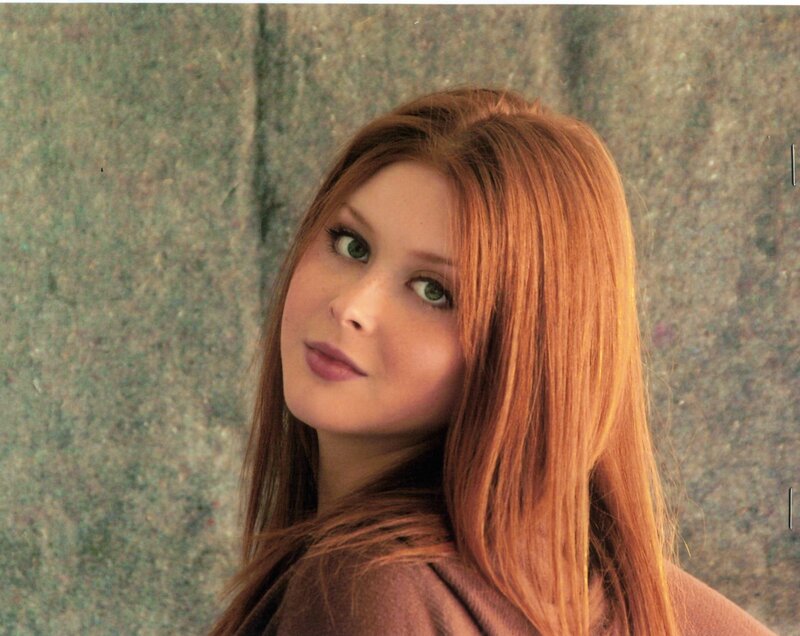 woman with red hair looking at camera