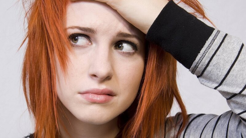 woman with red hair looking concerned