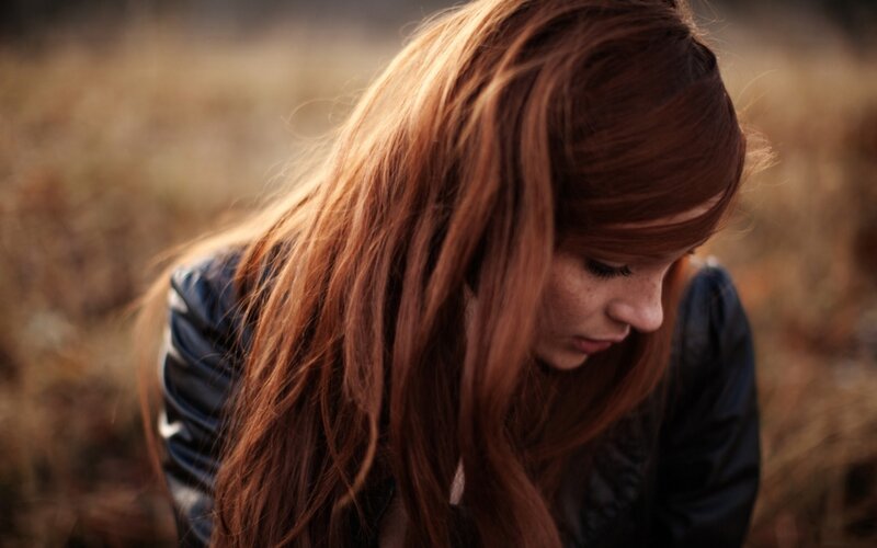 woman with red hair looking down