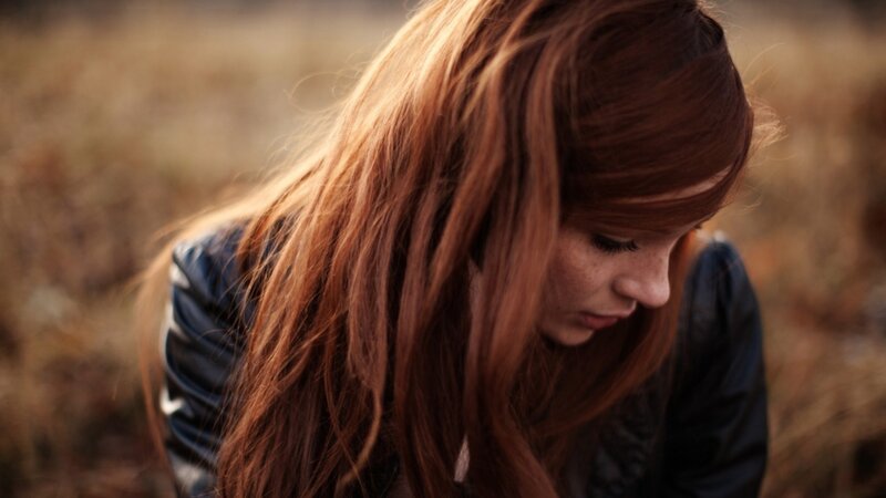 woman with red hair looking down