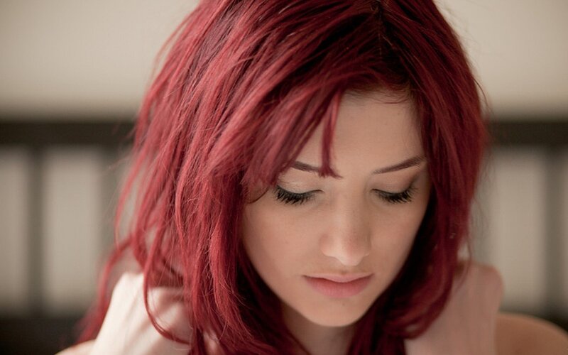 woman with red hair looking down
