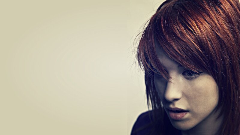 woman with red hair looking down