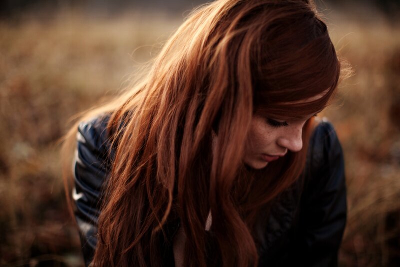 woman with red hair looking down