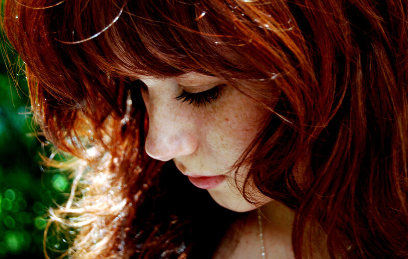 woman with red hair looking down