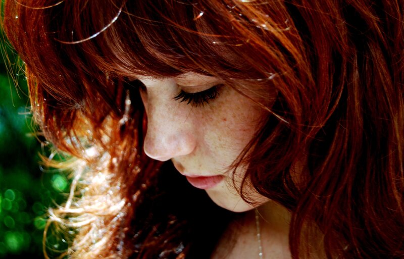 woman with red hair looking down