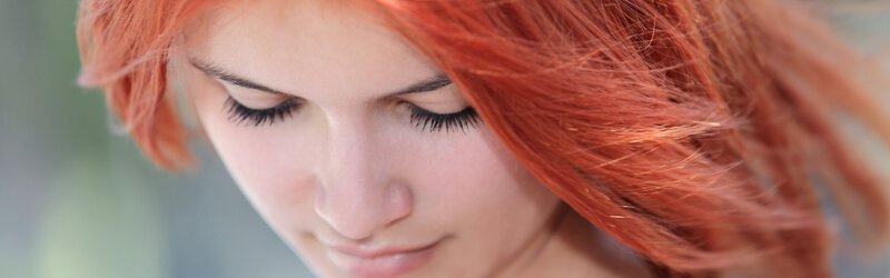 woman with red hair looking down