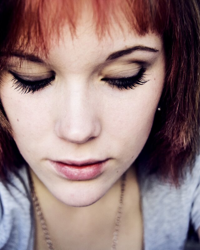 woman with red hair looking down